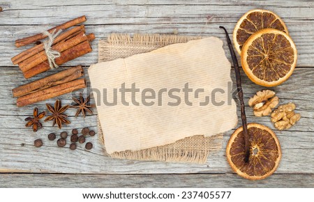 Spices background with paper: dried oranges, all spices, cinnamon, anise, walnuts