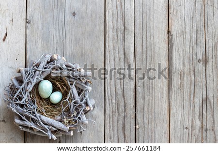 Easter eggs in nest on wood - rustic background