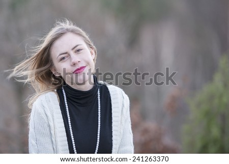 Teenage girl with black neck high pullover and pearl neckless