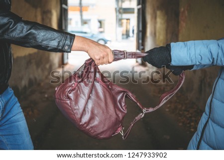 Robber snatches bag from hands of woman, close up. Criminal pickpocket and crimes on city street concept Foto stock © 