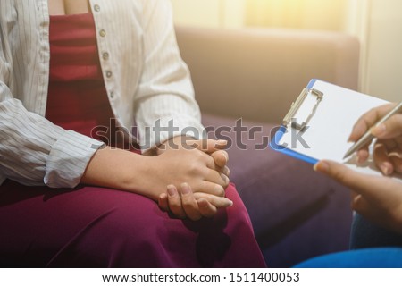Psychotherapist works and counsels young woman, closeup on hands, toned. Stockfoto © 