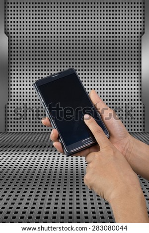 Mobile phone in hand on dot pattern of metal background