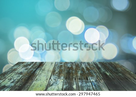 Blurred lights bokeh background with empty wooden deck table ready for product display montage. vintage color concepts