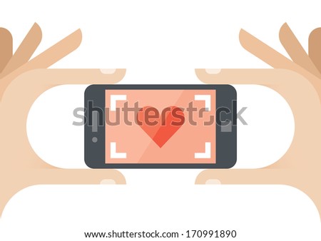 Taking a photo of Love with red heart on the screen of mobile phone. Concepts: wedding video, photos, honeymoon, engagement, valentines day celebration, love at first sign etc.