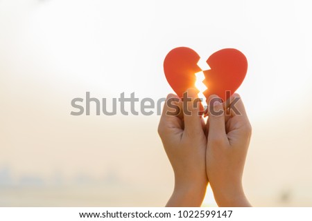 Woman hand holding broken paper red heart on sunset. Love, Wedding and Valentines day concept. Stockfoto © 