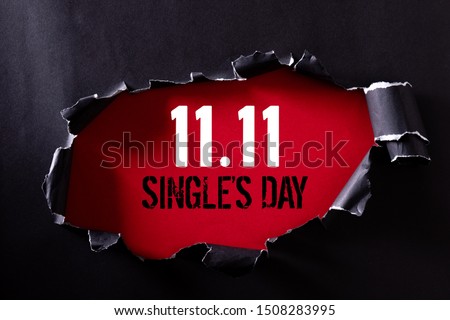 Online shopping of China, 11.11 single's day sale concept. Top view of Black torn paper and the text 11.11 single's day sale on a red background. Foto stock © 