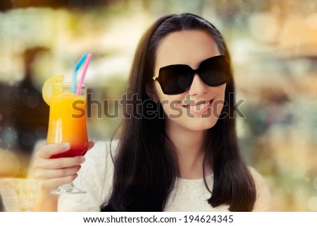 Young Woman with Sunglasses and Colorful Cocktail Drink Outside - Beautiful woman wearing sunglasses is enjoying a cocktail drink on a sunny day