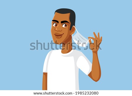Happy African Man Removing Medical Mask. Smiling person relaxing celebrating the end of the pandemic
