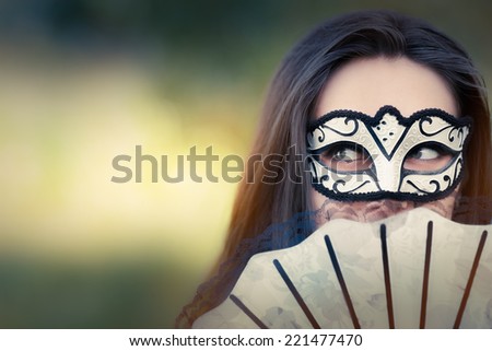 Young Woman with Mask and Fan - Portrait of a mysterious masked woman holding a fan