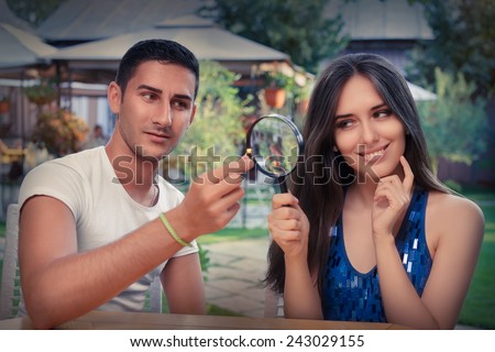 Happy Woman Testing Engagement Ring from Boyfriend with Magnifier - Young couple getting engaged in funny wedding proposal scene