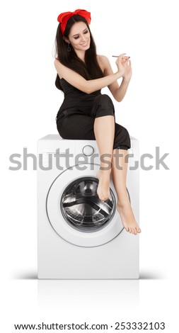 Beautiful Woman Filing her Nails on a Washing Machine - Young bored housewife spending time doing her manicure on a washer
