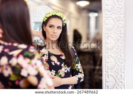 Beautiful Girl Looking in the Mirror and Trying on Floral Dress - Portrait of a young woman in a dressing room with a flower pattern dress