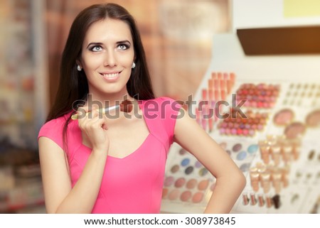 Happy Woman Holding a Make-up Brush - Smiling young girl in a cosmetics store in front of a make-up tester unit