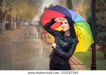 Happy Autumn Woman Holding Rainbow Umbrella Checking for Rain - Smiling fall girl wearing leather jacket outside in rainy weather