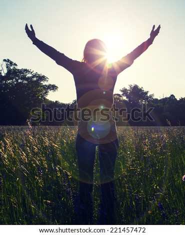 Young girl spreading hands with joy and inspiration facing the sun,sun greeting,freedom ,freedom concept