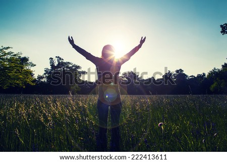 Young girl spreading hands with joy and inspiration facing the sun,sun greeting,freedom ,freedom concept,meditation zen