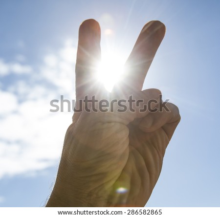 Hand to sun,sun rays passing through fingers