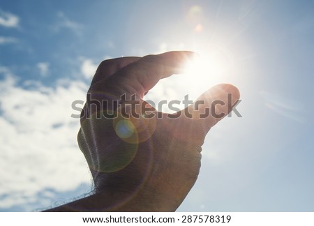 Hand to sun,sun rays passing through fingers