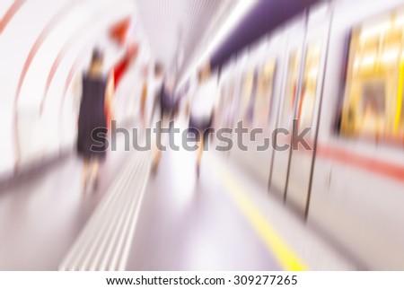subway train in metro station with motion blurred people walking