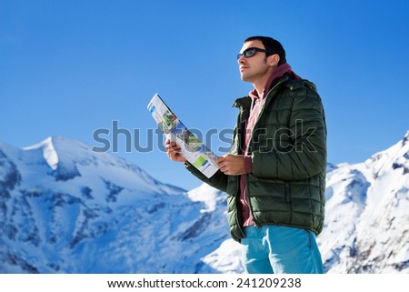 Man with a map looking forward to the background of snowy mountains. Grossglockner, Austria