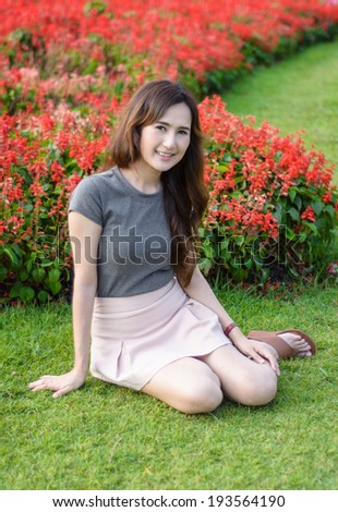 portrait single asia young woman sitting and smile on summer outdoor at natural garden