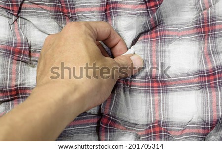 young man hand touching cotton fabric plaid pattern for background