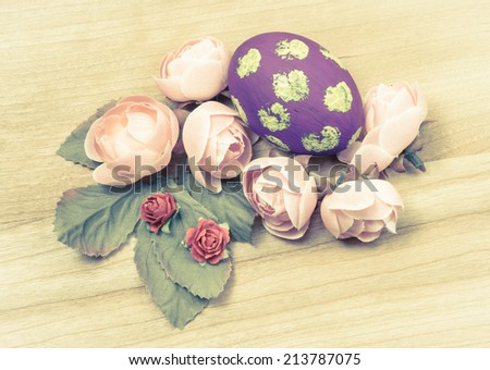 Easter eggs and flower deco on wooden background with retro filter