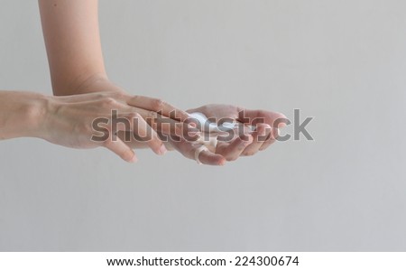 woman hands with skin care cream at wall background