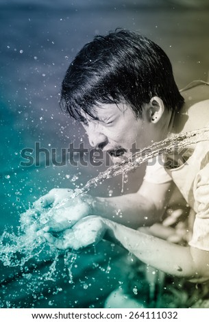 asia man washing him face and Water splash. with retro filter at outdoor