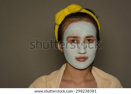 Young asia girl treatment blue facial mask on wall