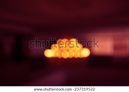 the blurry defocused image of yellow lighting from chandelier with orange highlight and red shadow