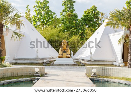 golden Sphinx statue with white pyramid building