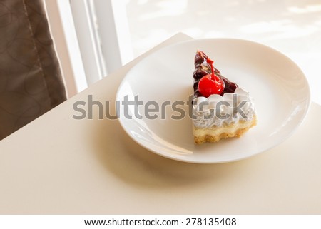 piece of blueberry cheese cake with cherry on top