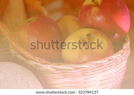 apple and bread in the basket with silver ornament ball, soft focus and color filter