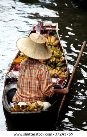 BANGKOK - JULY: A female vendor floats in a boat at the floating market (Damnoen Saduak) on July 18, 2009 near Bangkok. Thousands of Thailand travellers come and visit this scenic attraction every year.