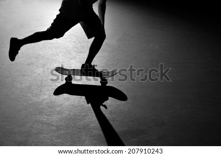 Silhouette of a skateboarder pushing through the skate park.