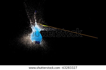 Balloon with water bursting punctured by arrow.High speed photography.