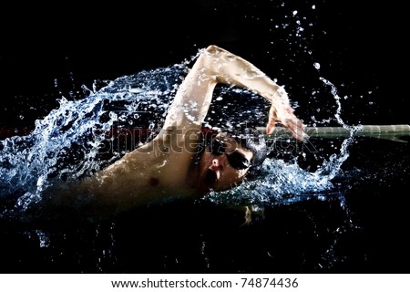 Professional swimmer crawl freestyle isolated black background