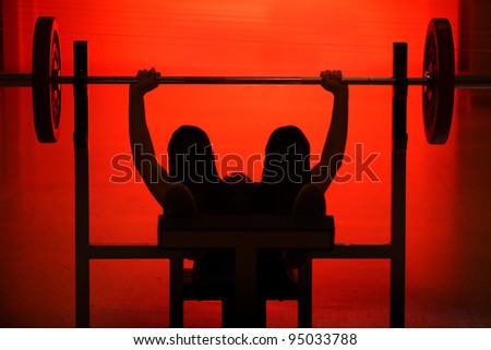 Athlete raising the bar black silhouette on red background