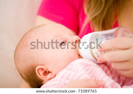 Feeding of the chest baby by a dairy mix from a children's small bottle