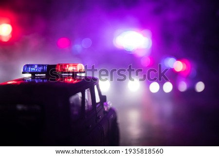 Police cars at night. Police car chasing a car at night with fog background. 911 Emergency response police car speeding to scene of crime. Selective focus 商業照片 © 