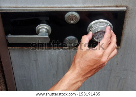 Hands of men open metal safe.