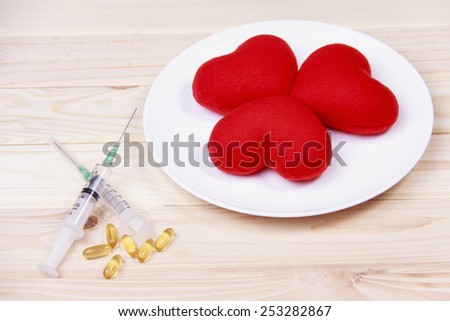 concept red heart on plate with  syringe and stimulant on wood background.Health care yourself should be done.