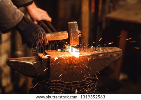 The blacksmith manually forging the red-hot metal on the anvil in smithy with spark fireworks Stock fotó © 