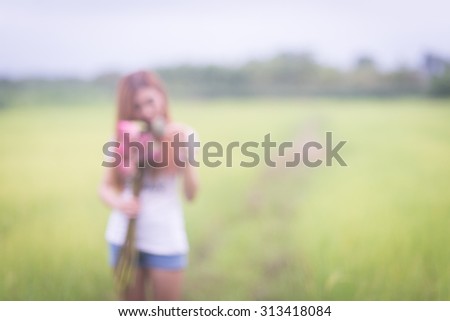 Abstract portrait of a asian girl/women for conceptual use, blur effect applied, shoot outdoor for travelling, holiday, relax use, (Portrait of girl holding flower in her hand and smelling it)