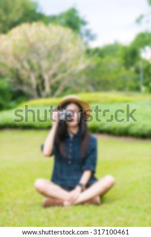 Abstract portrait of a asian girl/women for conceptual use, blur effect applied, shoot outdoor for travelling, holiday, relax  (blurred portrait of girl (asian women) holding on camera in the park)