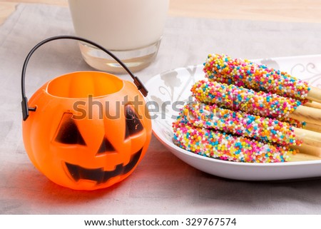 a pumpkin jack with milk and halloween candy for halloween holiday use (with selective focus technique applied)