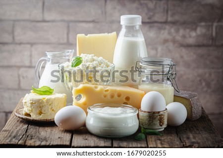 Fresh dairy products, milk, cottage cheese, eggs, yogurt, sour cream and butter on wooden table