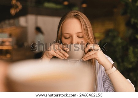 Similar – Image, Stock Photo Pensive woman drinking coffee and browsing smartphone at table