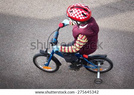 Boy on bike at asphalt road in spring